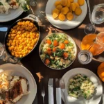 A collection of colorful Thanksgiving side dishes including roasted vegetables, mashed potatoes, and stuffing arranged on a festive table.